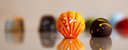 Close-up of colorful chocolate truffles on a reflective surface with a blurred background