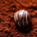 Chocolate truffle with striped pattern on a bed of cocoa powder