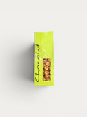 Norman Love Confections caramel popcorn in a bright green bag with a clear window showing the crunchy snack inside.