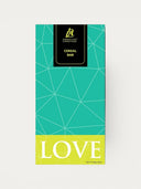 Norman Love Confections Cereal Bar with white chocolate, fruity cereal, and pop rocks. Teal and yellow packaging.