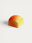 Norman Love Confections creamy vanilla cupcake with white chocolate frosting, ombre orange and yellow shell.