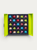 Norman Love Confections assorted dark chocolates in a bright green box, featuring 25 pieces in various shapes and colors.