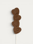 Norman Love Confections dark chocolate pop spelling LOVE with heart shapes.
