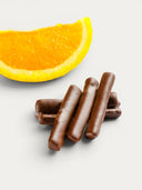 Norman Love Confections dark chocolate-covered orange sticks with a slice of fresh orange.