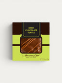 Norman Love Confections Dark Chocolate Caramel Pecan Turtle with diagonal milk chocolate drizzle.