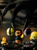 Norman Love Confections Halloween chocolates with a spooky claw hand reaching for a jack-o-lantern truffle.