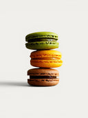 Norman Love Confections 12 piece macaron gift box featuring green, orange, and chocolate macarons.