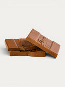Norman Love Confections milk chocolate bar with embossed logo, smooth texture, and segmented pieces.