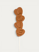 Norman Love Confections milk chocolate pop spelling out LOVE with heart shapes.