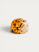Norman Love Confections Passion Panna-Cotta chocolate with orange and white chocolate shell splattered with black.