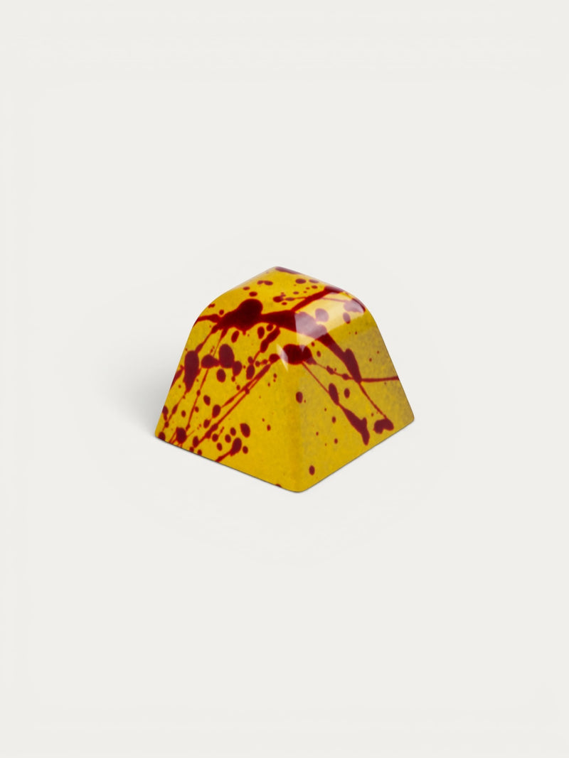 Norman Love Confections PB&J chocolate with yellow shell and red splatters.