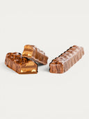 Norman Love Confections Peanut Caramel Bar with layers of caramel, peanut butter mousse, chocolate ganache, and peanuts.