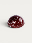 Norman Love Confections dark chocolate raspberry truffle with white speckles.