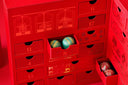 Norman Love Confections red advent calendar with 24 numbered drawers containing handcrafted holiday chocolates