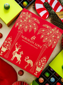 Norman Love Confections red advent calendar box with gold palm tree and reindeer art, surrounded by holiday treats.