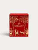 Norman Love Confections red advent calendar with gold foil palm trees, reindeer, and flamingo holiday illustrations.