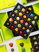 Norman Love Confections 50-piece signature chocolate box with assorted milk, dark, and white chocolates in a green gift box.