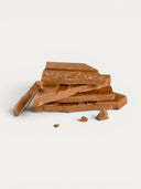 Norman Love Confections vegan milk chocolate bar, broken into pieces, with embossed logo.